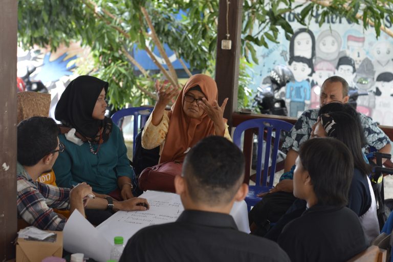 6 orang dari komunitas Tuli sedang duduk melingkar, diskusi tentang kebutuhan untuk penanganan kasus Tuli