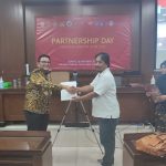 Program Manager SAPDA Ayatulloh menerima plakat dari perwakilan Fakultas Hukum UGM.