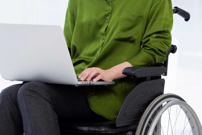 Ilustrasi Perempuan Disabilitas sedang Bekerja Menggunakan Gawai Laptop