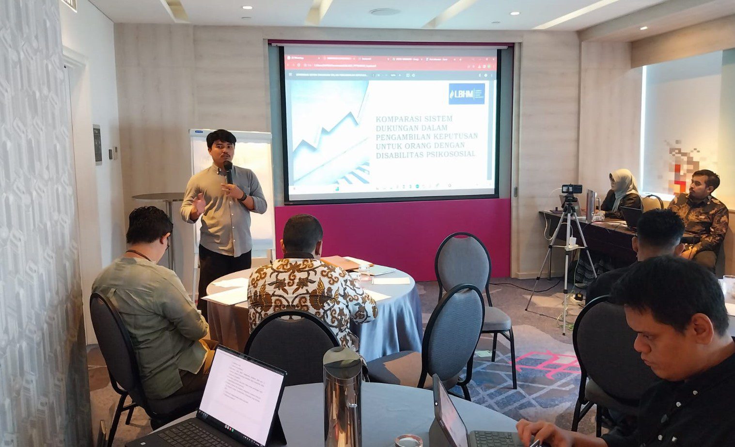 5 sampai 6 orang sedang berkumpul di dalam sebuah ruangan mengikuti lokakarya.